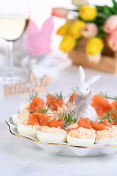 Appetizer of eggs stuffed salmon pate and yolks with salmon slices. Idea Easter table 