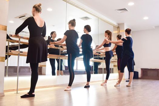 Side view Groups of Girls performing exercises on the bar at the gym with a focus on athleticism in a health and fitness concept.