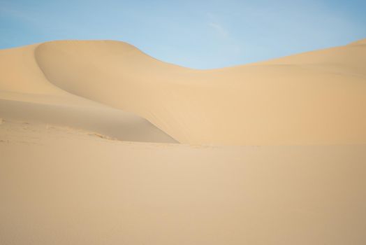 Sandy dune against a blue sky