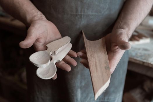 Spoon master in his workshop with wooden products and tools. High quality photo