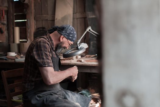 Spoon master in his workshop with wooden products and tools. High quality photo