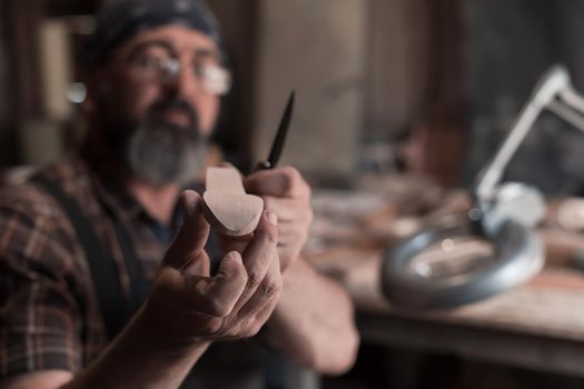 Spoon master in his workshop with wooden products and tools. High quality photo