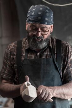 Spoon master in his workshop with wooden products and tools. High quality photo