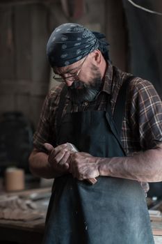 Spoon master in his workshop with wooden products and tools. High quality photo