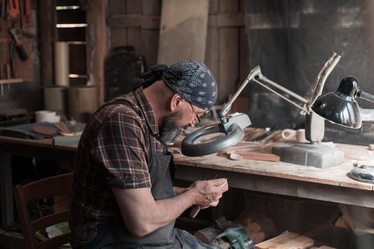 Spoon master in his workshop with wooden products and tools. High quality photo