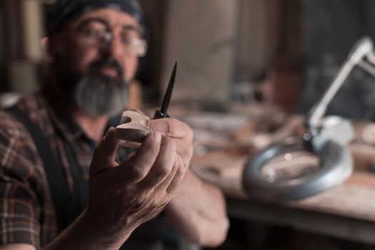 Spoon master in his workshop with wooden products and tools. High quality photo