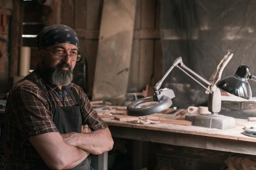 Spoon master in his workshop with wooden products and tools. High quality photo