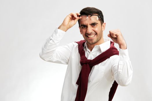 man in a white shirt sweater on the shoulders pensive look glasses isolated background. High quality photo