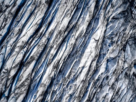 Aerial view of glacier from above, ice and ashes of the volcano texture landscape, beautiful nature ice background from Iceland