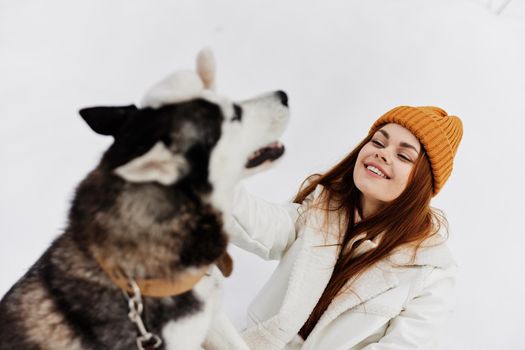 woman in the snow playing with a dog fun friendship fresh air. High quality photo