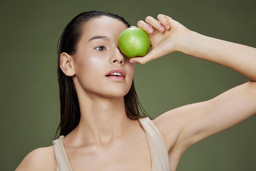 brunette green apple near face health close-up Lifestyle. High quality photo