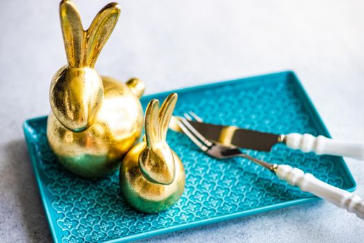 Place setting for festive Easter dinner using with golden bunnies