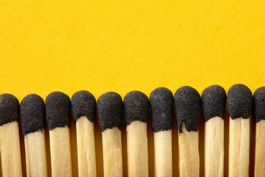 Matches on a yellow background, an abstraction about teamwork and modern relationships.