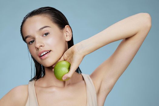 brunette in hands posing fruit healthy food fresh blue background. High quality photo