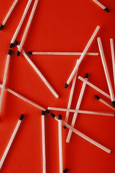 Matches on a red background, an abstraction about teamwork and modern relationships.