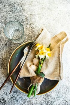 Minimalistic table setting for easter festive dinner  decorated with daffodil flowers