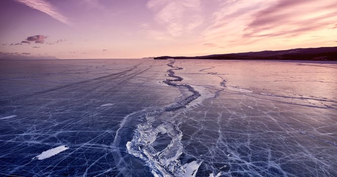 Frozen lake Baikal, at dawn. Winter landscape panorama