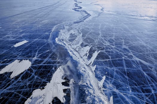 Texture of ice of Baikal lake in Siberia. blue lake ice.