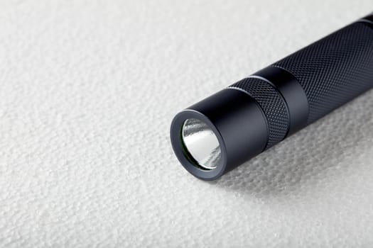 Black flashlight with a beam of light on White background