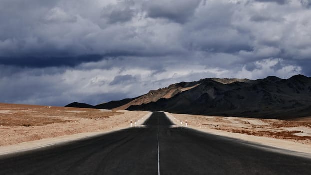 Road to the mountains. Paved road on the background of mountains. Road photography, Traveling by car.