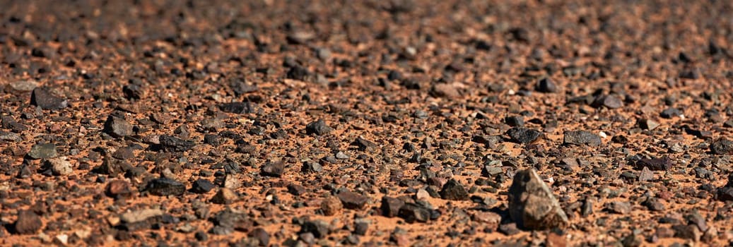 Black Gobi. Stony desert, black stones on the sand. Abstract natural background.