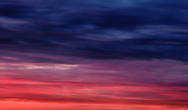 Colorful sunset with clouds in the evening. Abstract nature background. Dramatic and moody pink, purple and blue cloudy sunset sky.