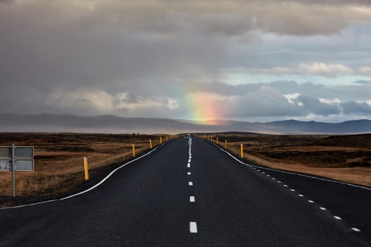 Road, mountains and rainbow. Roadtrip in Iceland. car trip