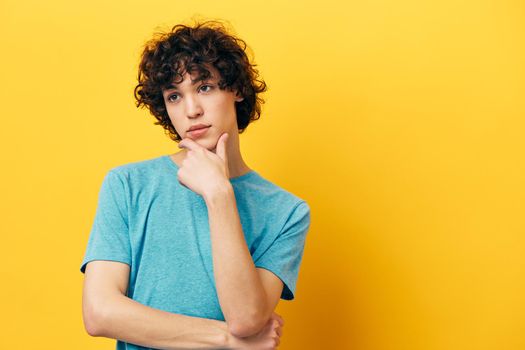 teenager guy blue t-shirts on a yellow background portrait. High quality photo