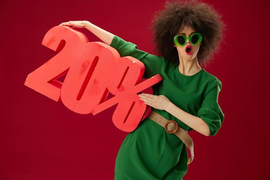 pretty woman green dress afro hairstyle dark glasses twenty percent in hands color background unaltered. High quality photo