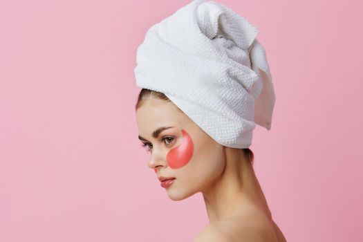 young woman pink patches on the face with a towel on the head isolated background. High quality photo