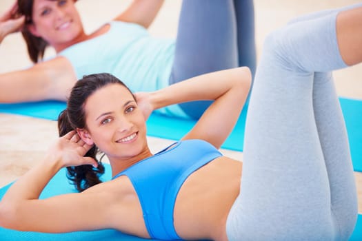 Young woman doing a sit up during a pilates class.