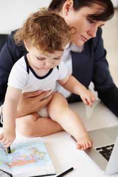 Working mother holding a baby while talking on the phone.