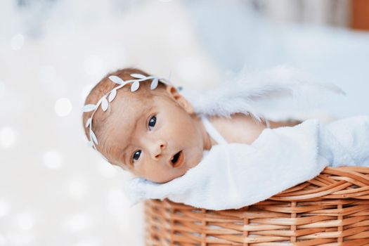 close-up. cute newborn baby angel looking out of the baby basket.