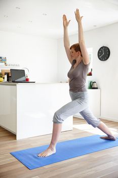 Shot of an attractive woman doing yoga in her home.
