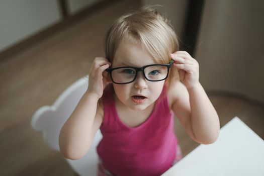 portrait of a little funny girl in eyeglasses 