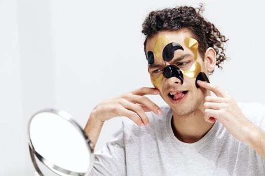 portrait of a man many patches on the face touches face with hands isolated background. High quality photo