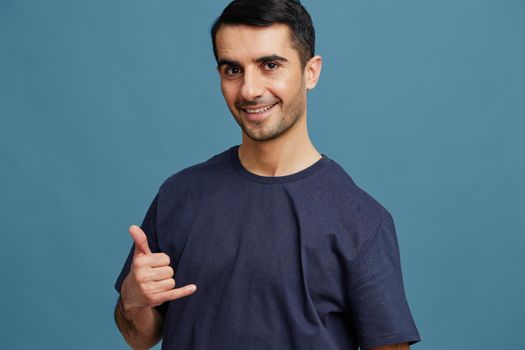 smiling man gesture with hands blue t-shirt casual wear. High quality photo