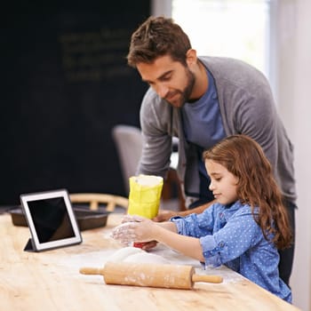 Shot of a father and daughter baking together in the kitchen.