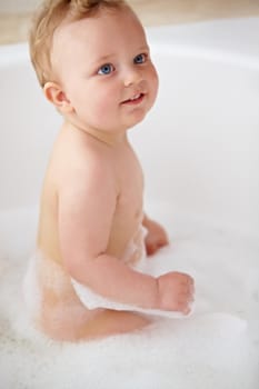 Cropped shot of a baby boy smiling in the bathtub.