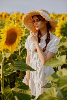 beautiful sweet girl in a white dress walking on a field of sunflowers unaltered. High quality photo