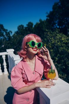 glamorous woman in green sunglasses with cocktail in summer outdoors unaltered. High quality photo