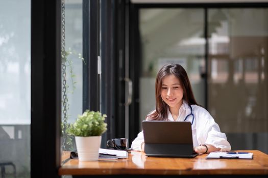 Portrait happy asian woman doctor in hospital, female using smart digital tablet
