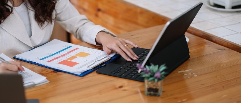 Close up of businesswomen or accountant using laptop computer while working analytic business report on the workplace, Planning financial and accounting concept.