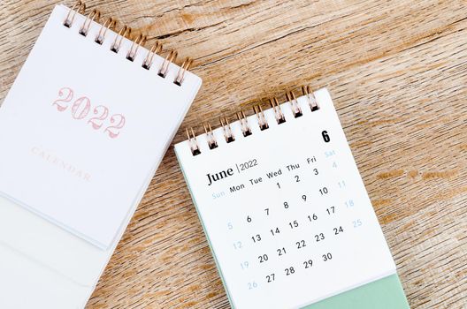 The June 2022 desk calendar on wooden background.