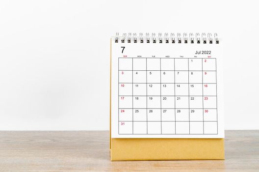 The July 2022 desk calendar on wooden background.