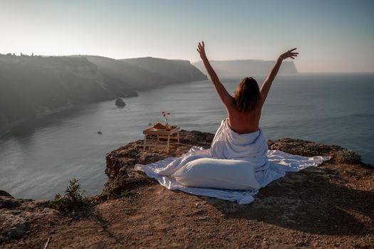 Woman wake up in bed wuth duvet and pillow over nature sea background outdoors. Back view. Good morning. Freedom concept