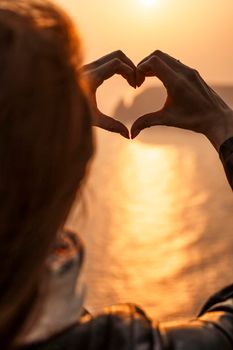 Women's hands symbol of the heart lifestyle and feelings concept with sunset light nature on a winter background. Valentine's day.