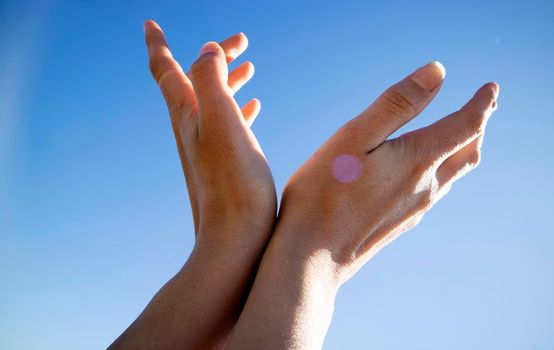 Photographic representation of female hands projected towards the blue sky in backlight 
