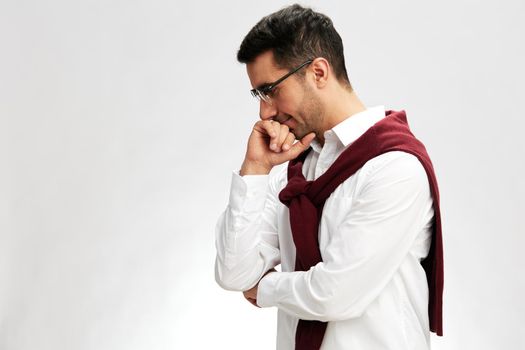 man in a white shirt sweater on the shoulders pensive look glasses light background. High quality photo