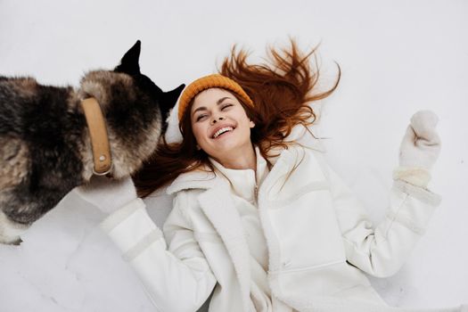 portrait of a woman in the snow playing with a dog fun friendship winter holidays. High quality photo